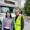 two people standing in front of a shuttle bus